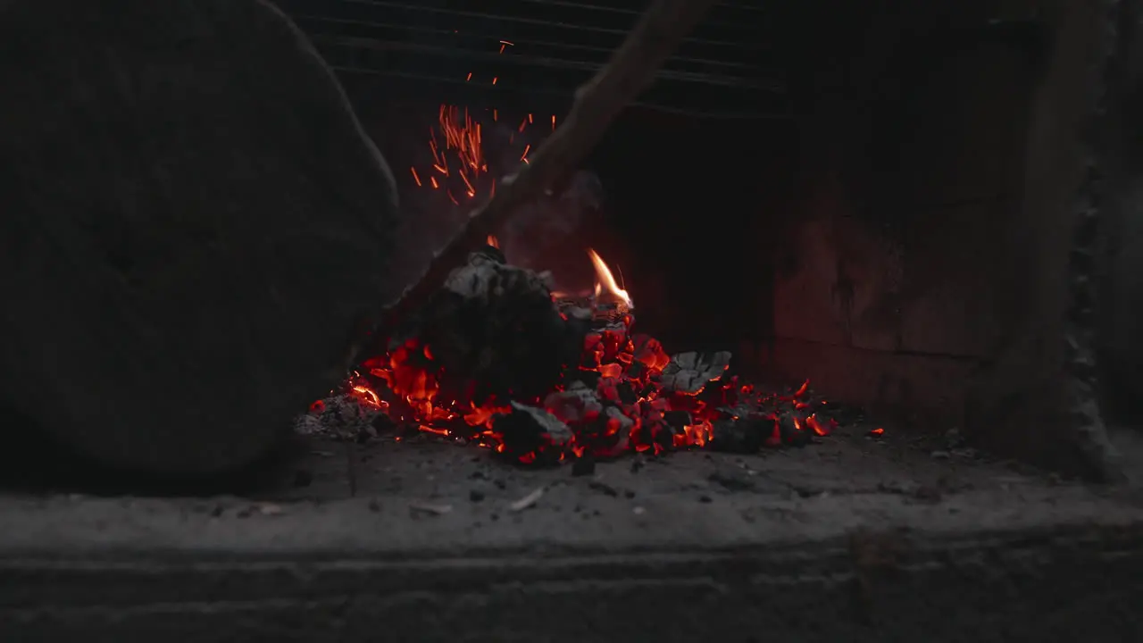 Moving campfire charcoal at dusk