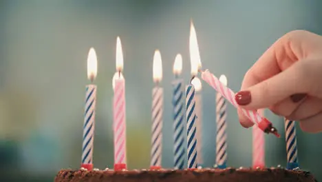 Woman hand put candle flame in birthday cake Burning candle in birthday pie