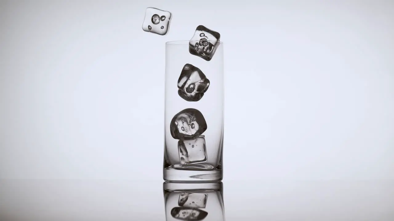 Multiple Ice Cubes Falling into an Empty Glass