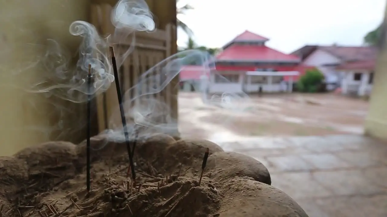 Slow motion incense burning in a temple courtyard