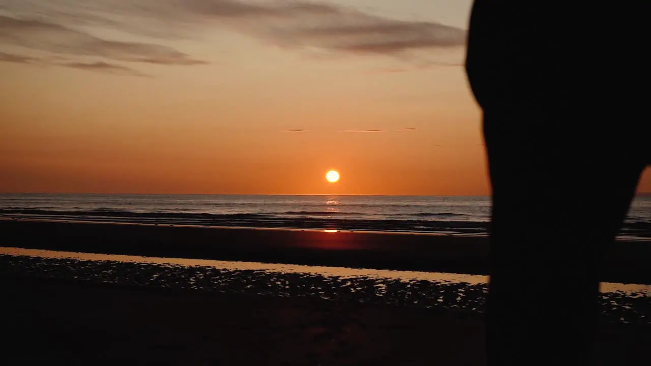 Man running with guitar in back sand beach at sunset-30