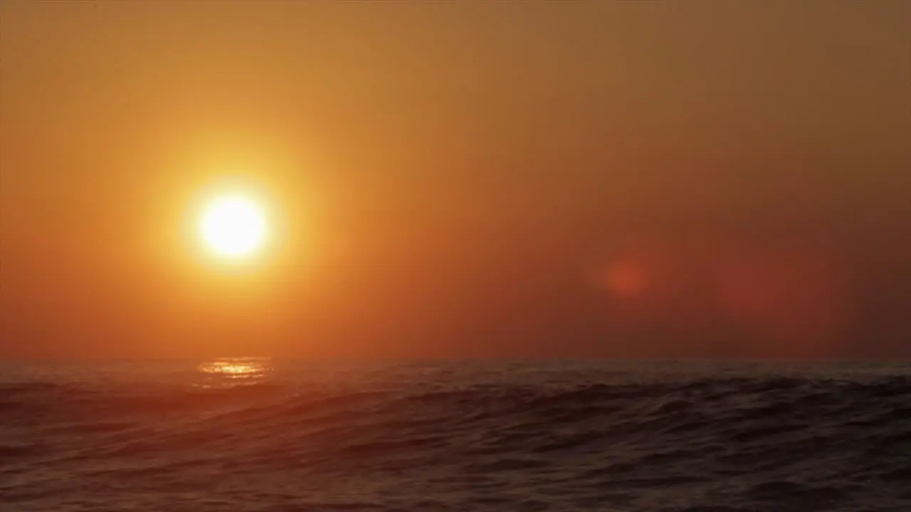 The sun sets behind beautiful ocean waves