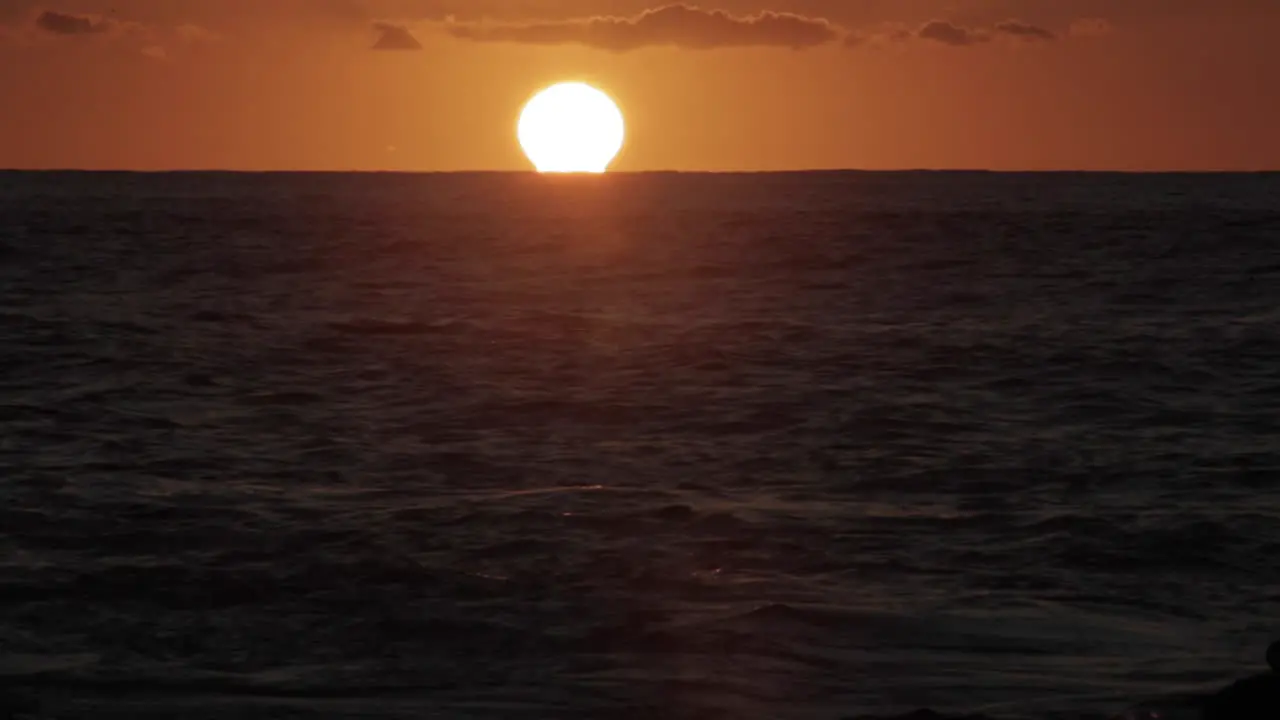 Time lapse shot of sun setting behind ocean waves 1