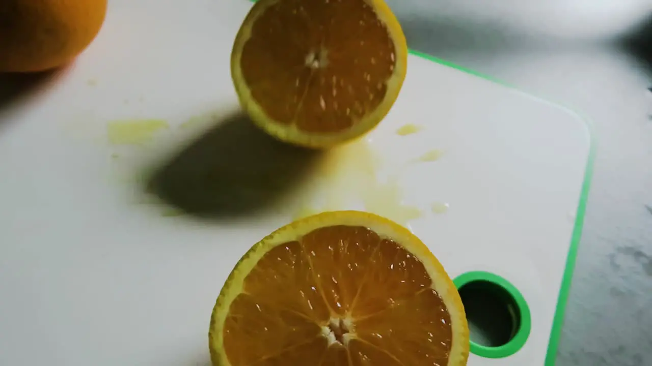 Making orange juice cutting the oranges on a chopping board close up