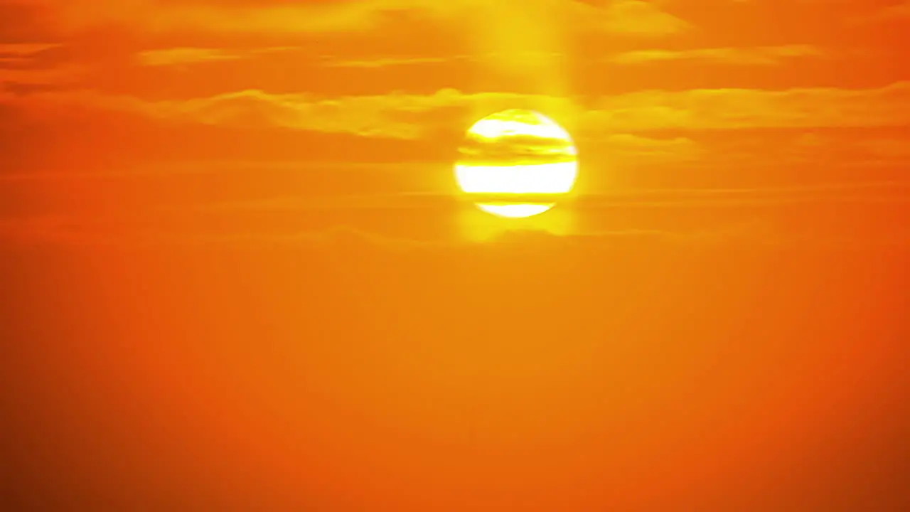 Dramatic sunrise in yellow sky through orange clouds in timelapse at dawn