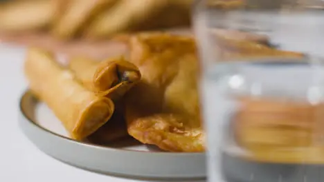 Close Up Of Plate Of Samosas And Glass Of Water On Marble Surface Celebrating Muslim Festival Of Eid