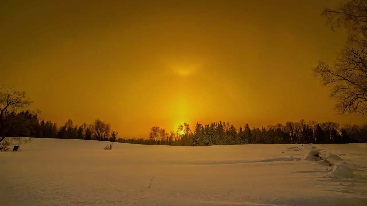 Golden yellow sun halo sunrise over a magical winter field time lapse