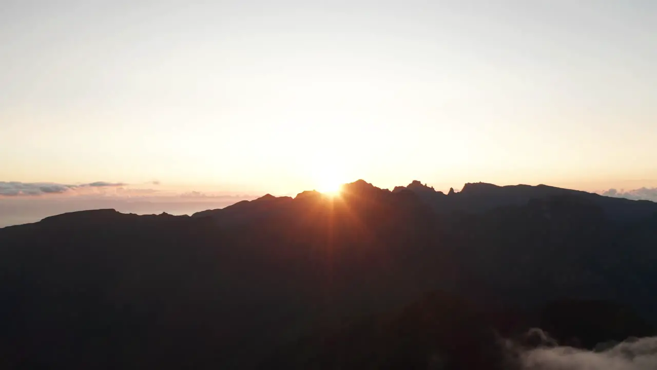 Morning sun shines bright over edge of mountains in Madeira aerial