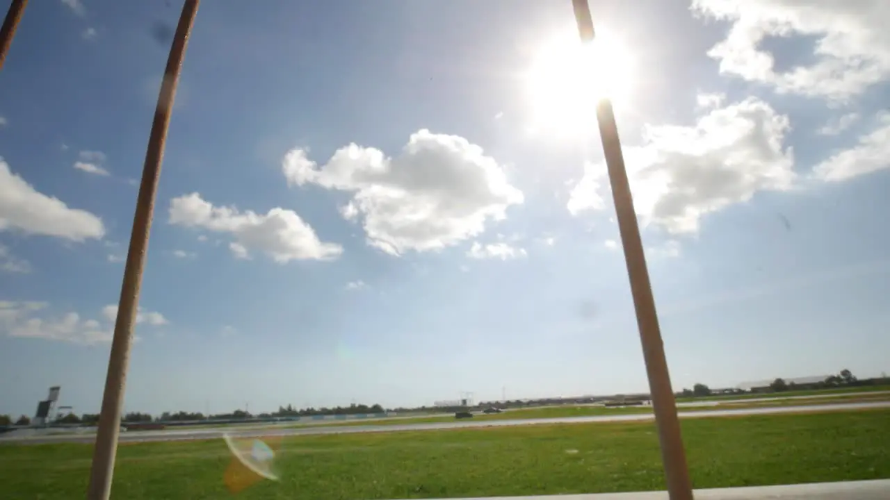 A look over the railing to reveal a car racetrack on a sunny day with cinematic lens flares