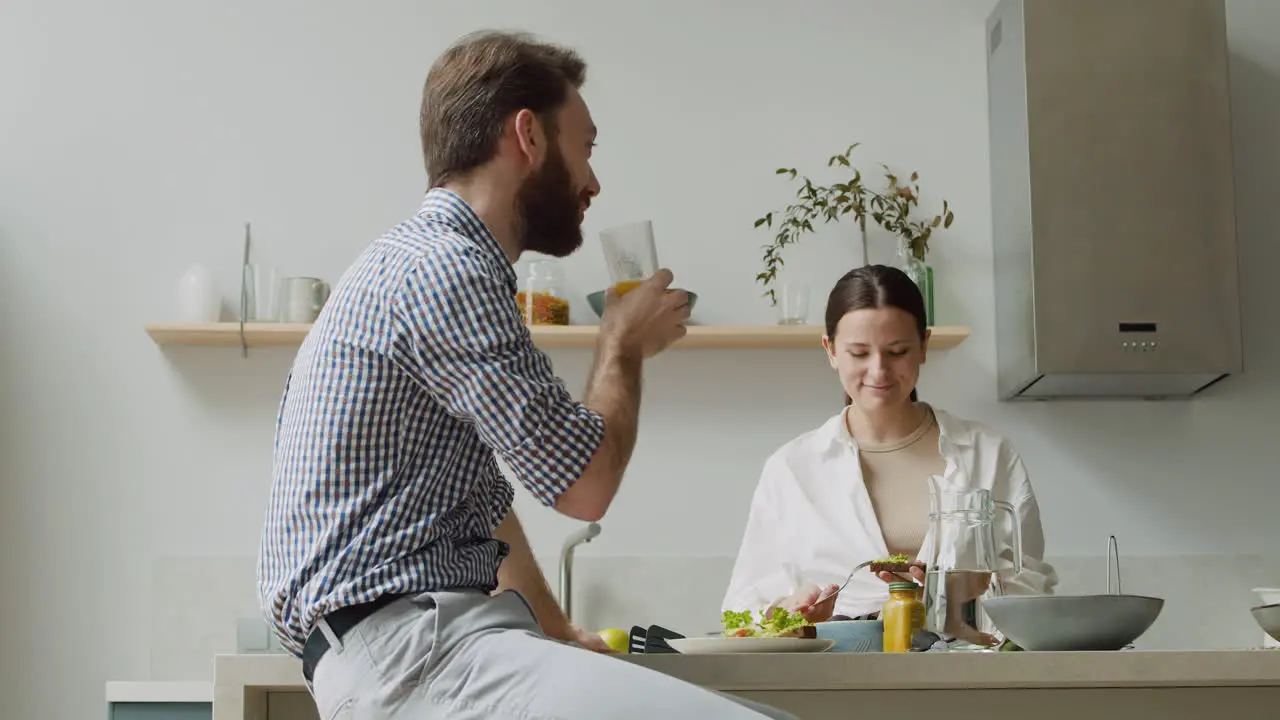 Laughing Couple Chatting And Having Lunch Together In A Modern Kitchen