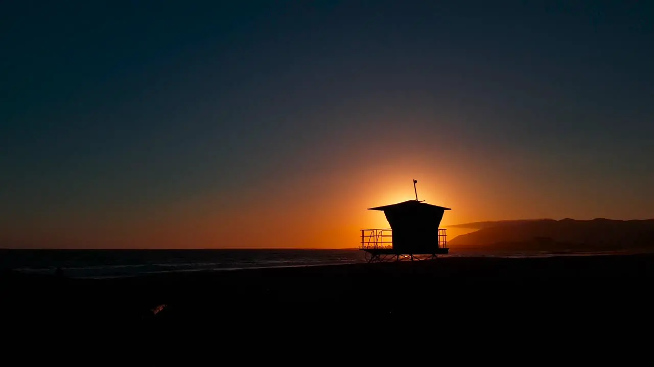 Slow sideways sunset shot at San Buenaventura State Beach with Lifeguard house  tower in Ventura California United States