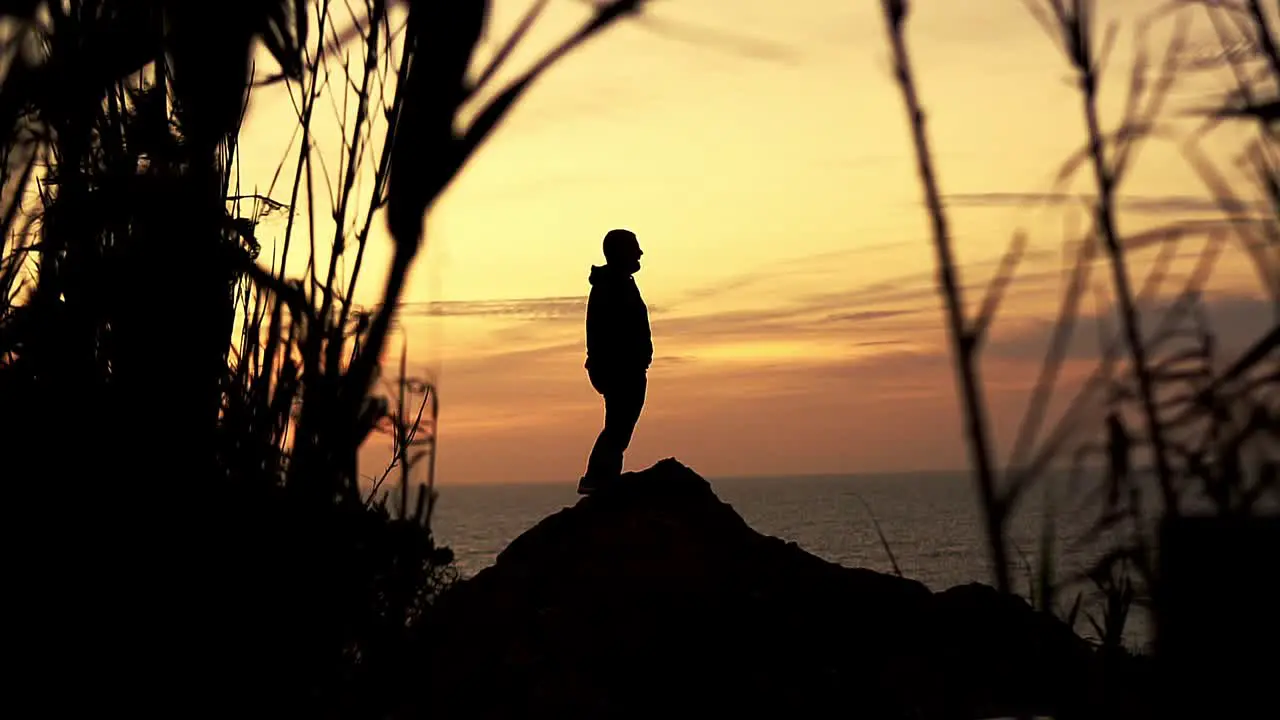 Silhouette of a man on a mound at sunset golden hour