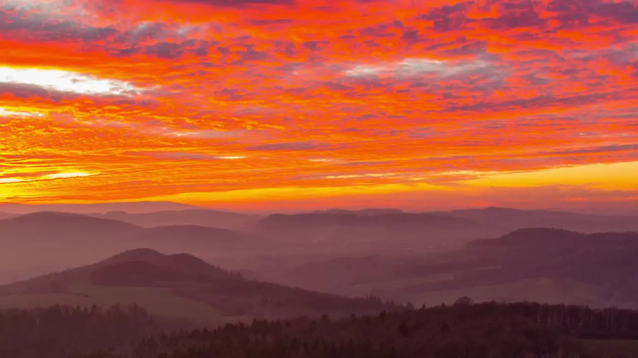 The beautiful red orange sunset over the low mountains of Ostrzyca Proboszczowicka Poland time lapse