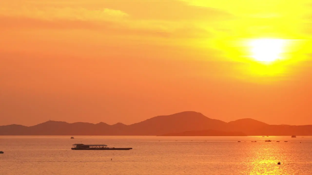 Golden Hour Sunrise Sunlight Over Calm Tropical Sea Boats and Hill Silhouette on Coast of Tropical Island