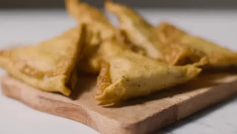 Close Up Of Samosas On Wooden Board On Marble Surface Celebrating Muslim Festival Of Eid