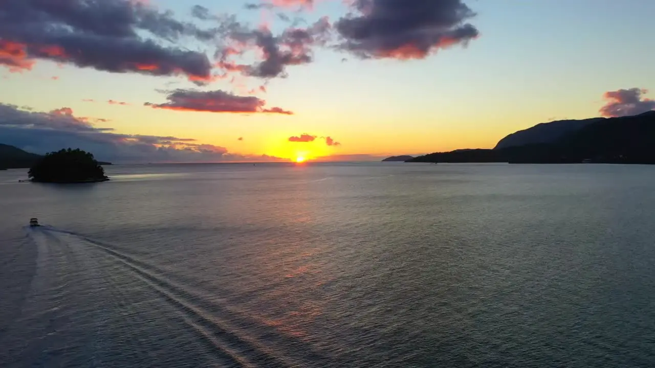 Aerial drone shot towards the sunset over the lake