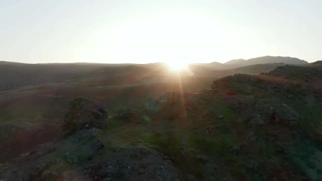 Spiral aerial view backlight of Iceland countryside with mossy rocky formations and steaming fumaroles Backlit drone view at sunset of wild stunning nordic icelandic highlands Amazing in nature