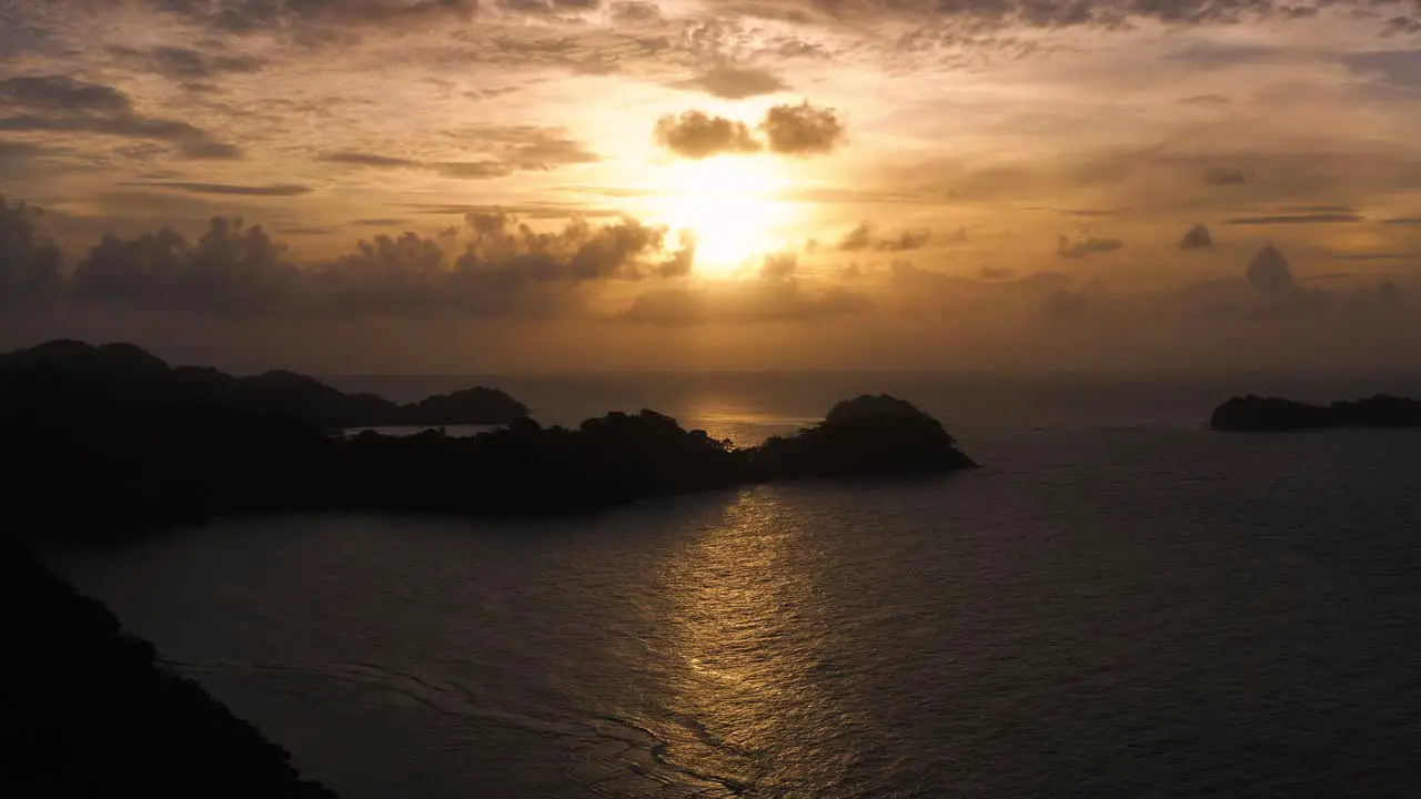 Panama tropical island silhouette golden magic hour sunset coastline aerial view pull back along coast