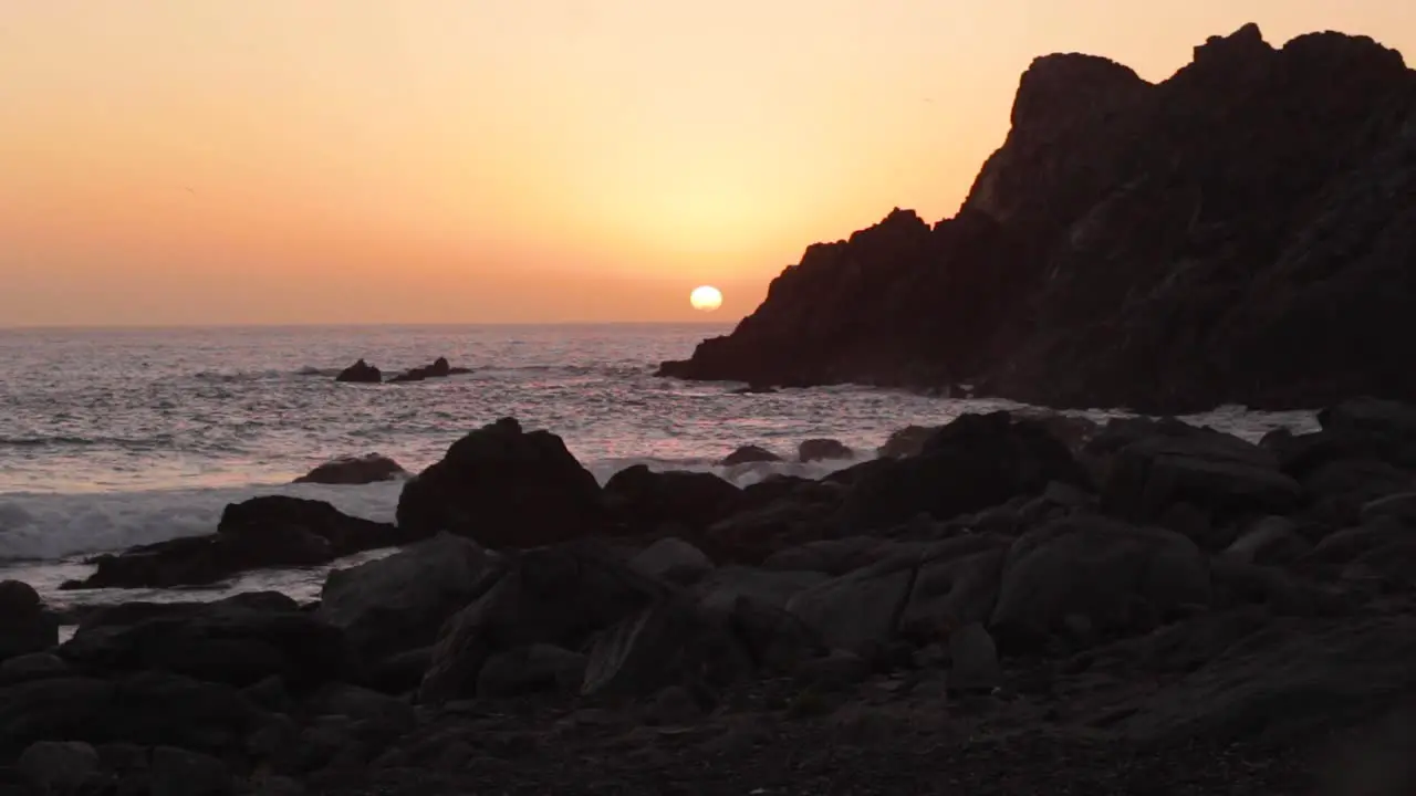 Beautiful sunset in the beach with waves crashing