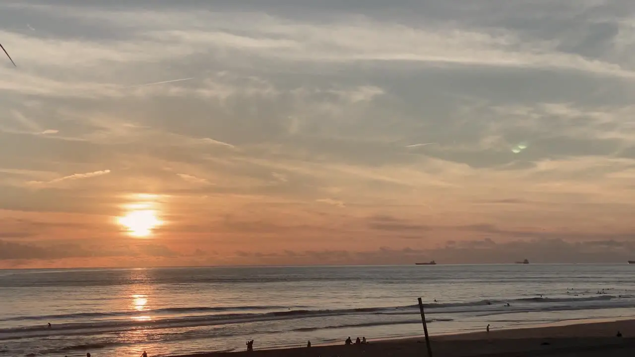 Romantic view from the sandy beach to the ocean at sunrise with dramatic clouds