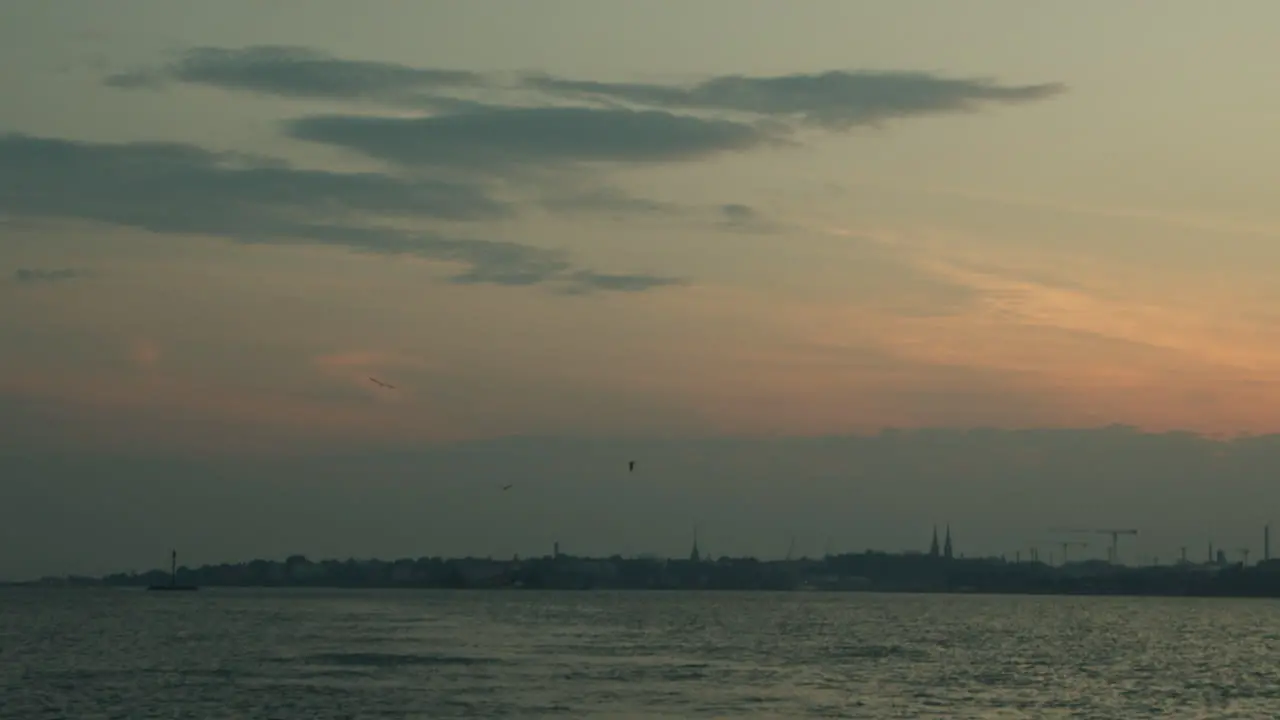 City Silhouette at Sunset with Seagulls and Calm Sea in Helsinki Finland on a Warm Summer Day