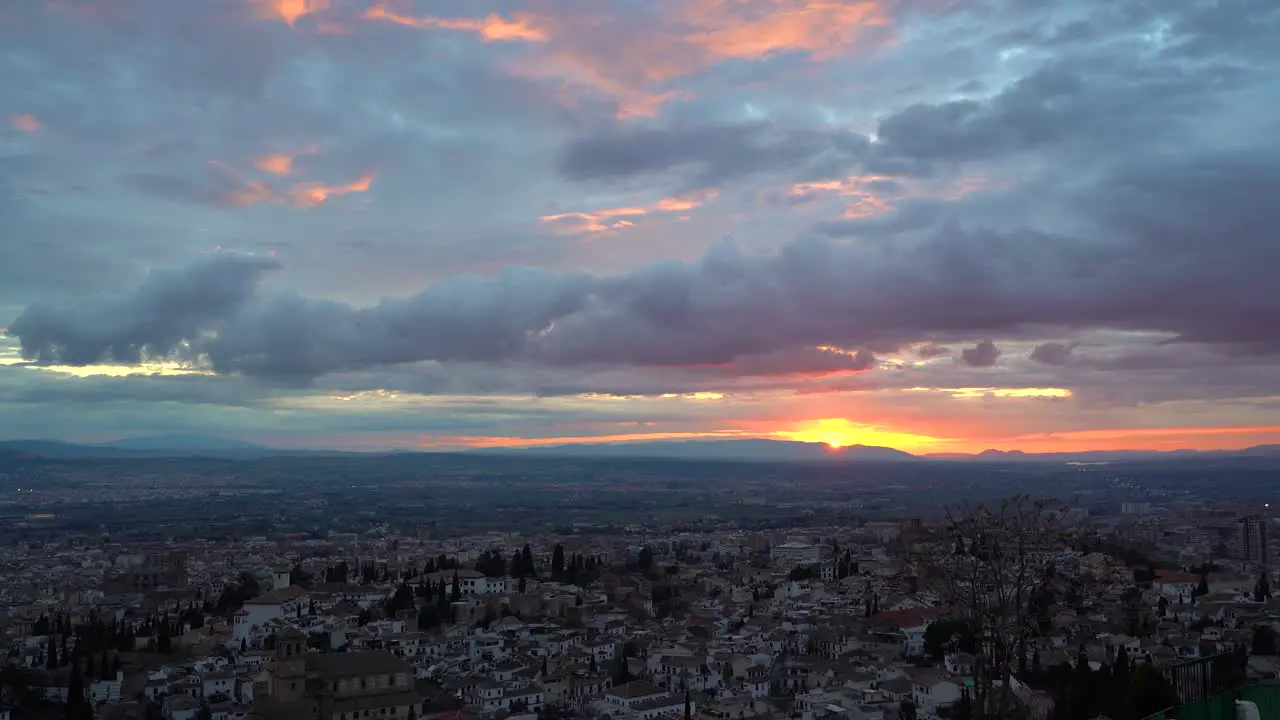 Incredible sunset view over Granada cityscape at sunset with colorful clouds