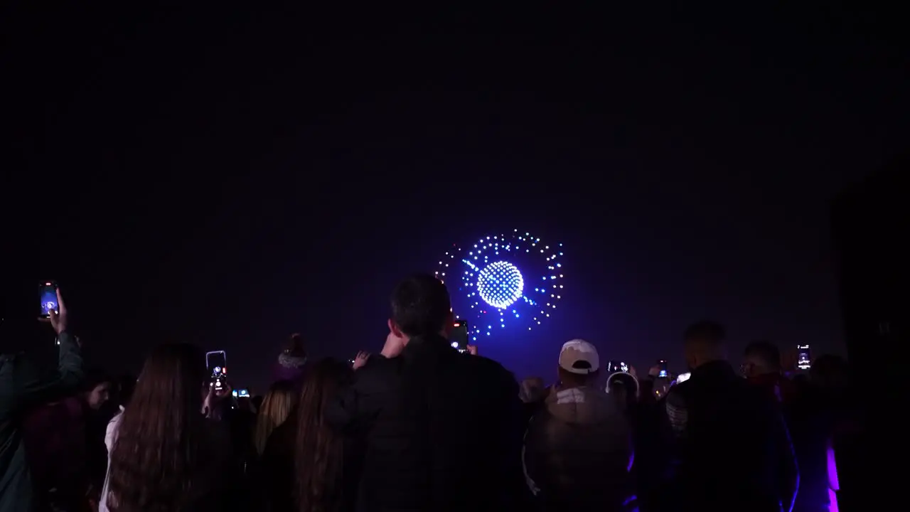 Spectacle in the Sky Captivating Nighttime Drone Show Draws Crowd for People-Watching and Smartphone Filming