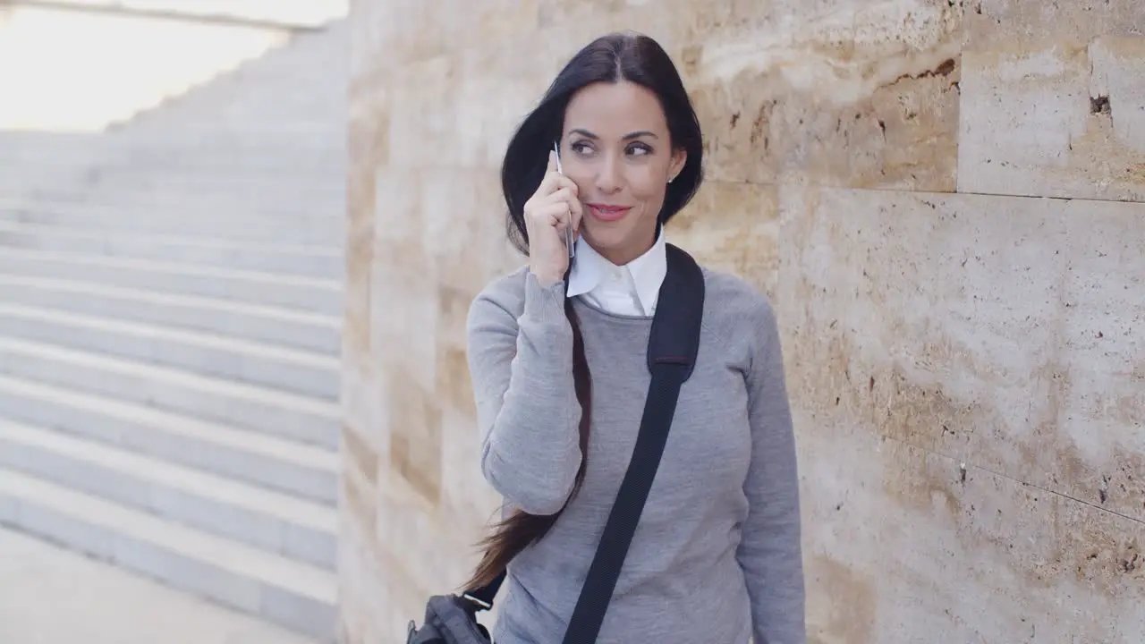 Happy woman in sweater talking on phone