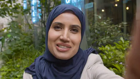 POV Shot Of Muslim Businesswoman Making Video Call On Mobile Phone Outdoors In City