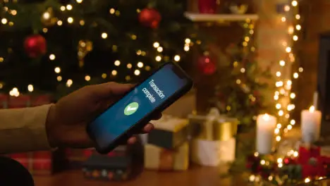 Christmas At Home With Person Making Card Purchase On Mobile Phone