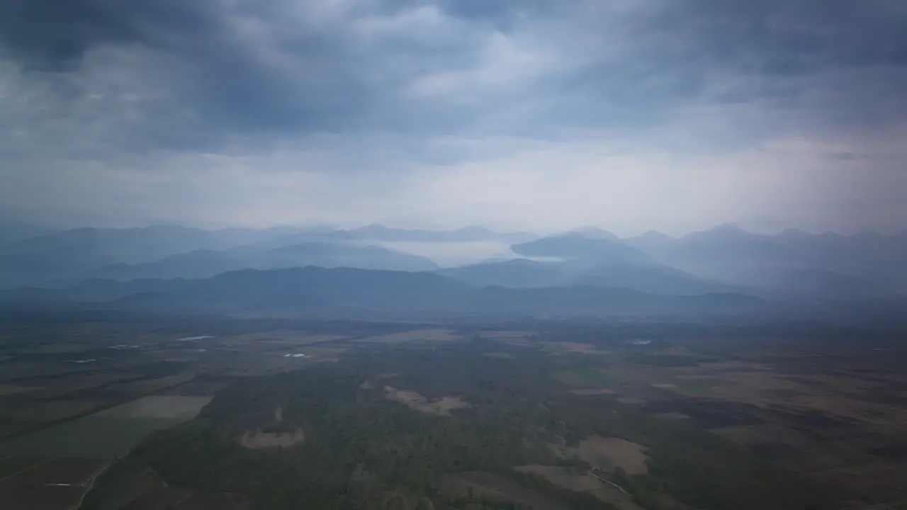 Aerial timelapse over empty fields in Georgia with the Caucasus Mountains and clouds in the background