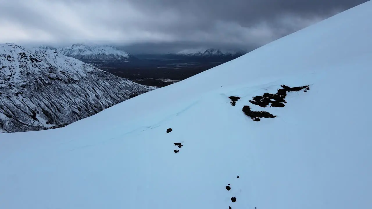 Aerial view of snow-covered mountain ridge as the camera moves back