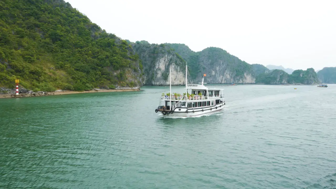 Ha Long Bay Cruise Passing Cruise Boats with Rocky Limestone Mountains on a Gloomy Day