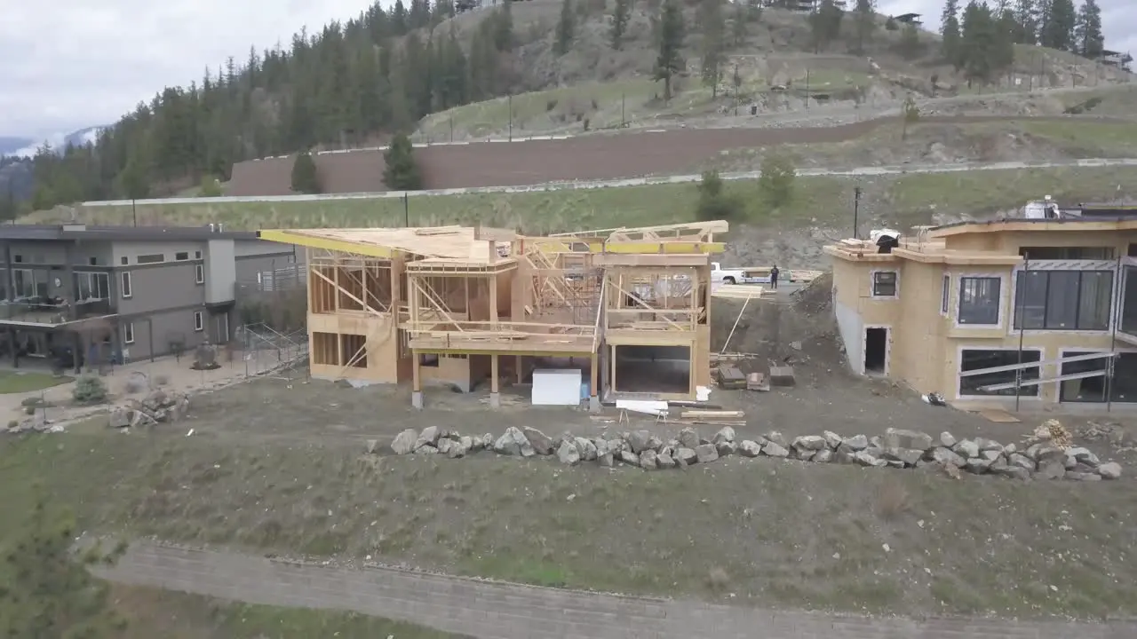 An aerial Drone shot of a house overlooking a lake being constructed