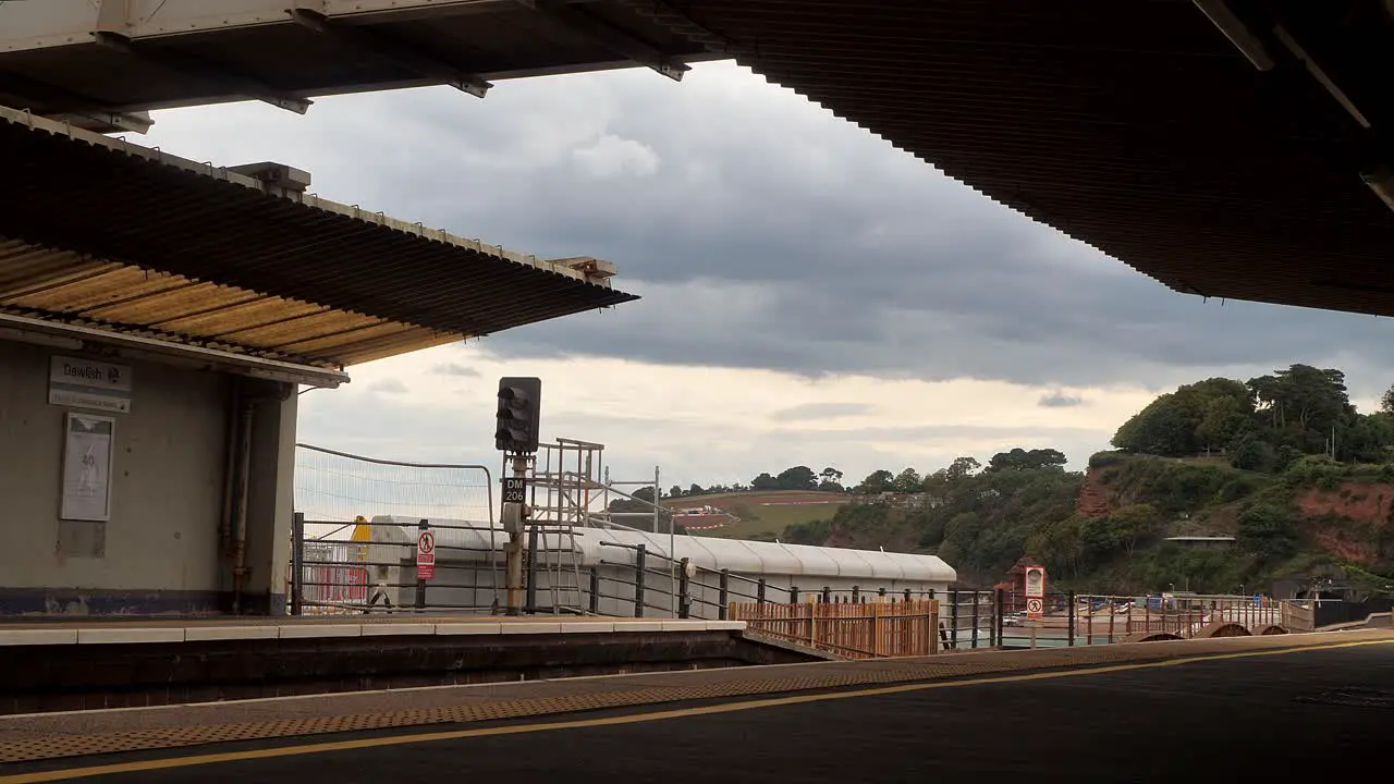 Train pulls out of Dawlish Railway Station Devon UK under a grey sky