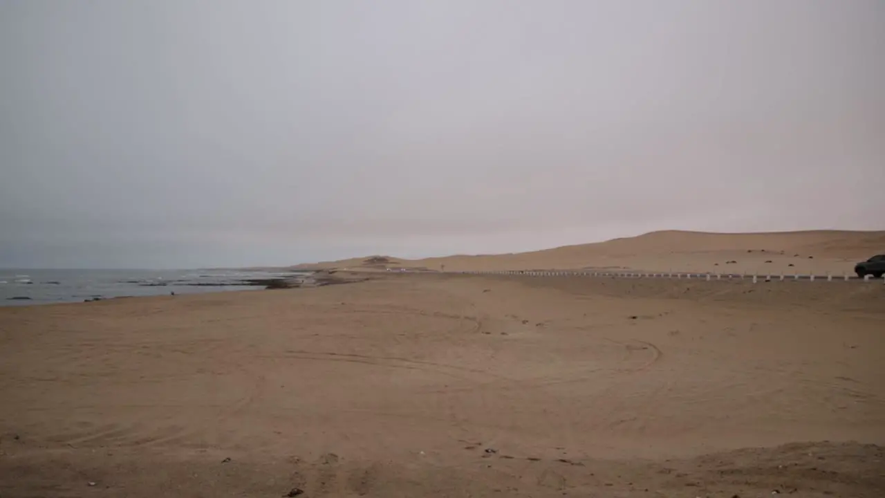 The national road from Swakopmund to Walvisbay next to the desert and ocean on a cloudy day