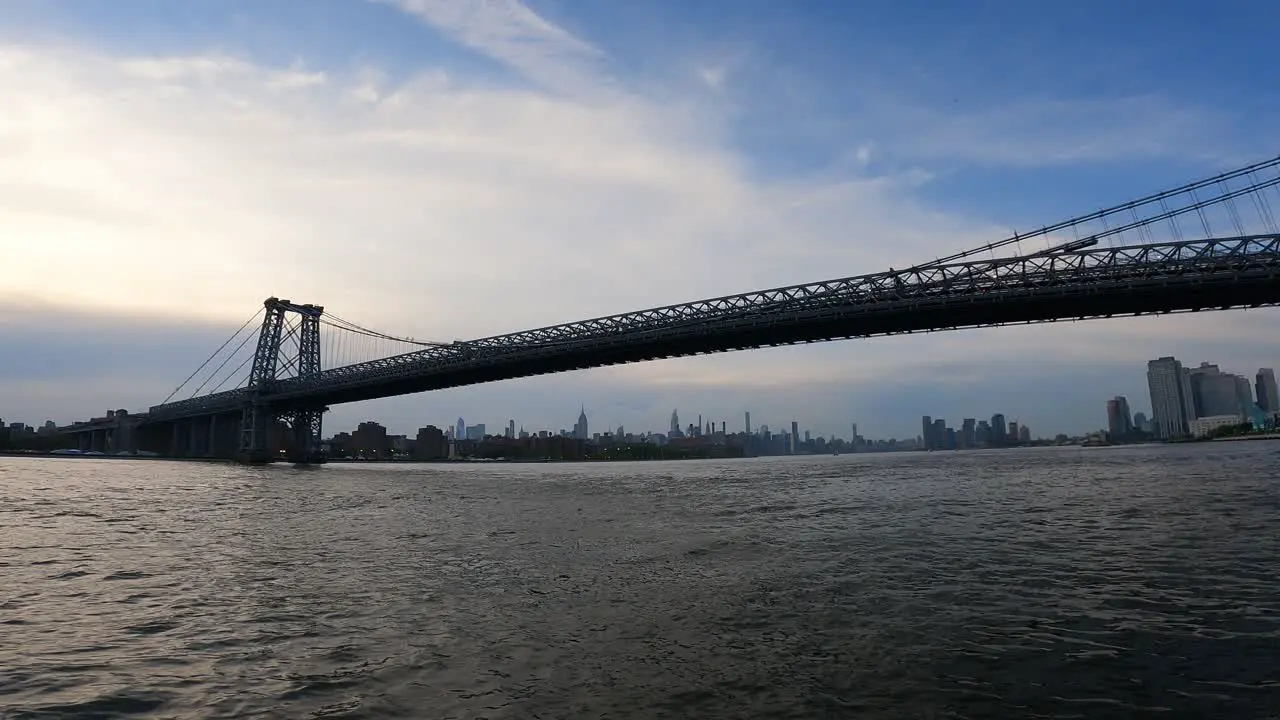 Boat crossing under large bridge in Manhattan New York