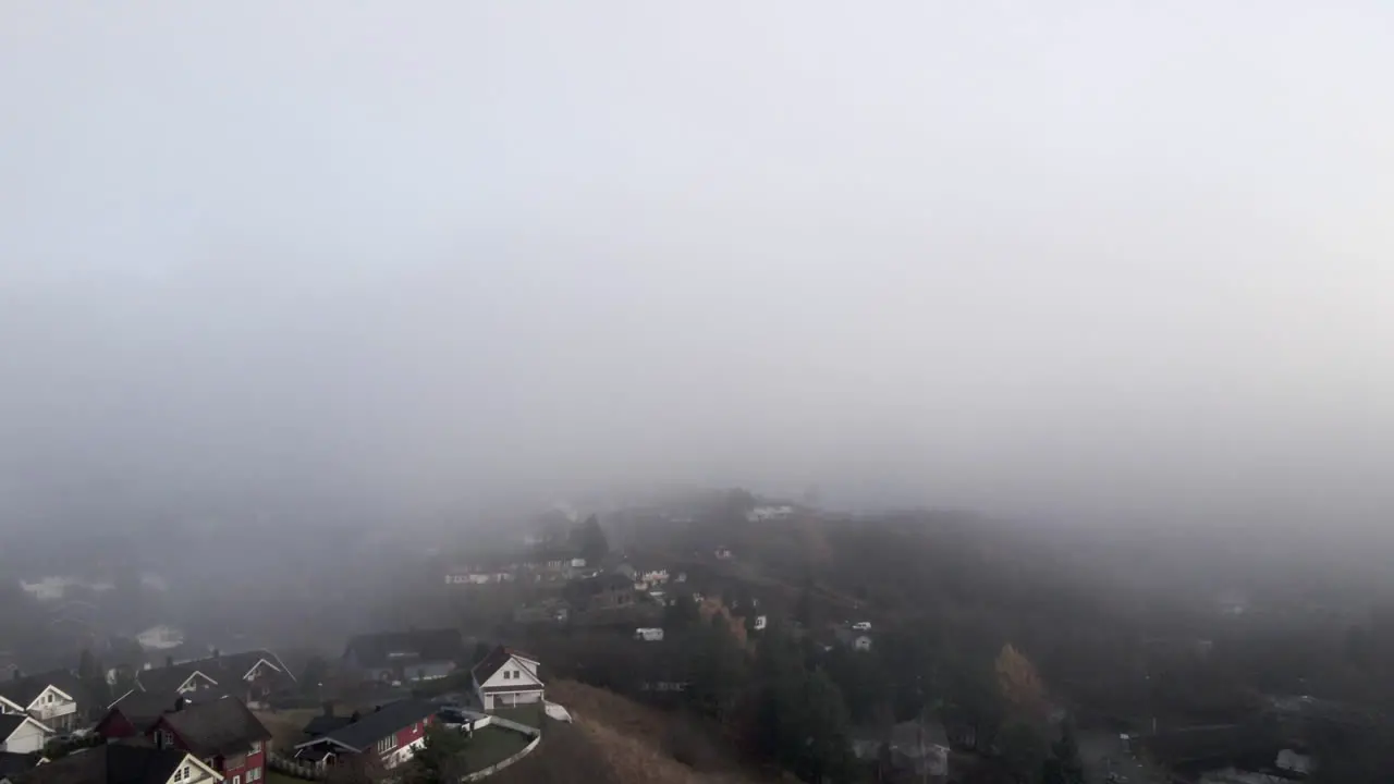 A neighbourhood in a foggy day filmed from the sky