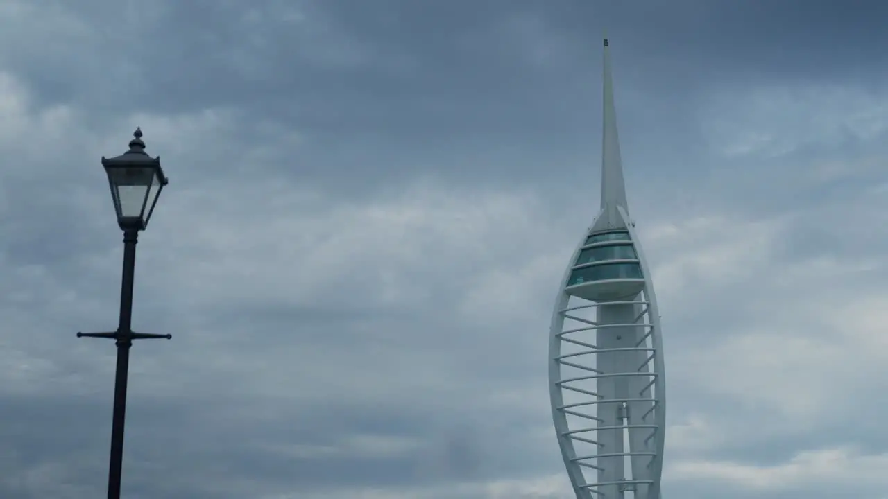 The Spinnaker Tower in Portsmouth next to a Victoria lamppost on a cloudy day