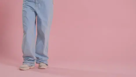 Close Up On Legs And Feet Of Woman Having Fun Dancing Against Pink Studio Background