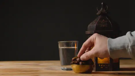 Stationary Shot of Hand Taking a Date On a Table for Ramadan