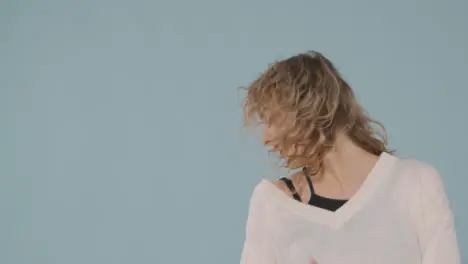 Studio Shot Of Young Woman Having Fun Dancing Against Blue Background 3