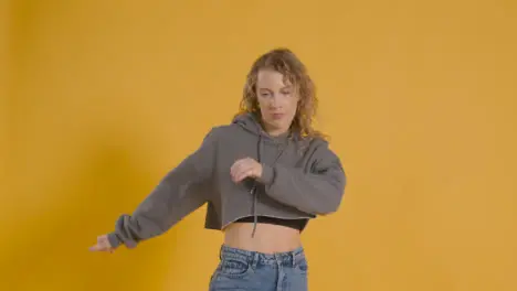 Studio Shot Of Young Woman Having Fun Dancing Against Yellow Background 1