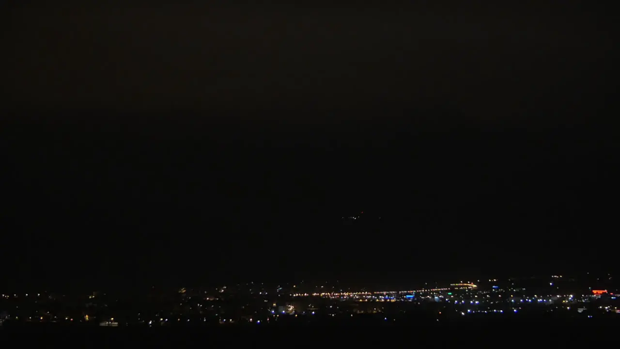 Illuminated night city and lightning flashes