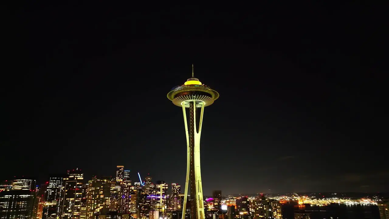 Cinematic establishing view looking up at the Space Needle aerial at night in Seattle with city lights