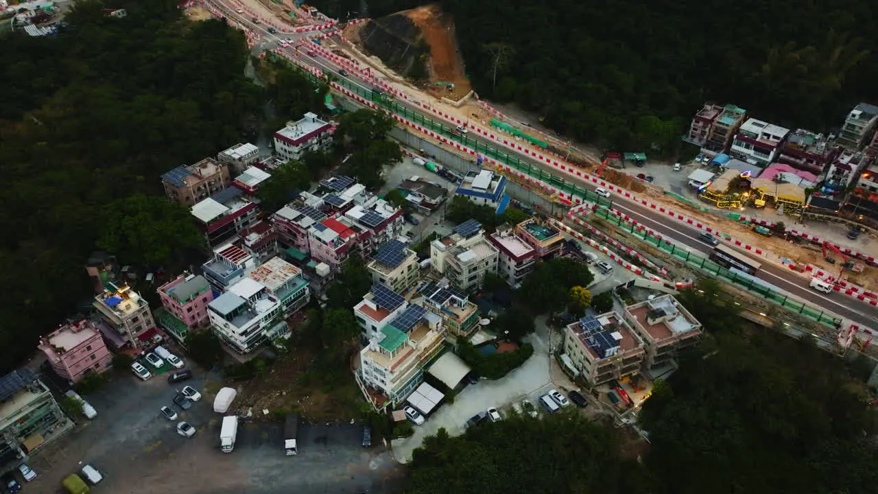 Drone beautiful rotating shot of a local group of houses next to a road