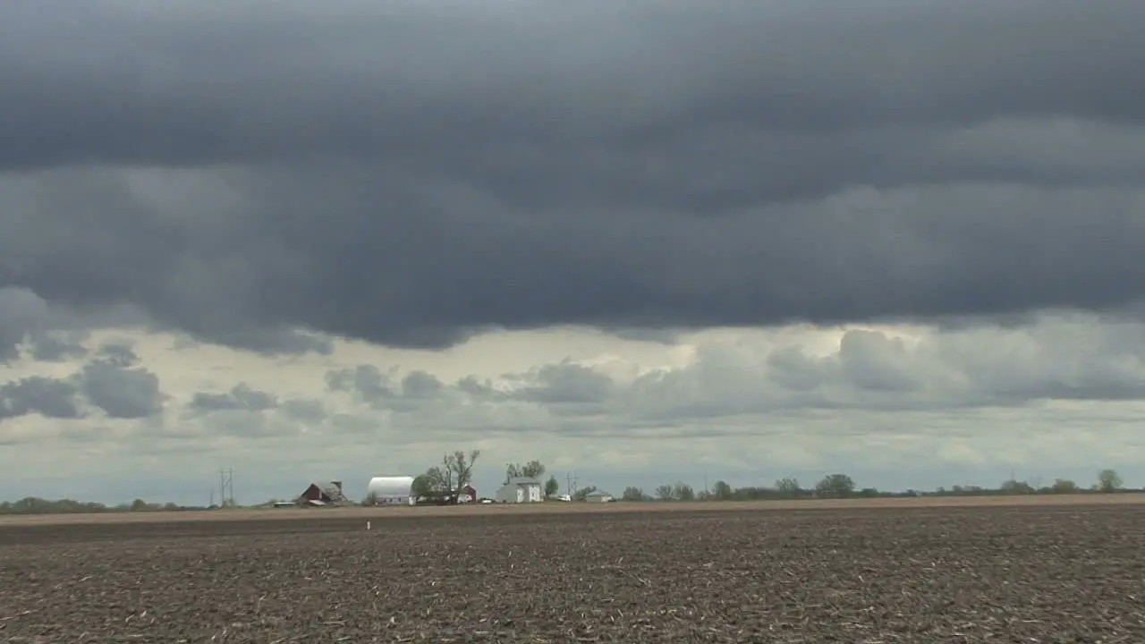 Dark clouds over flat land zoom out