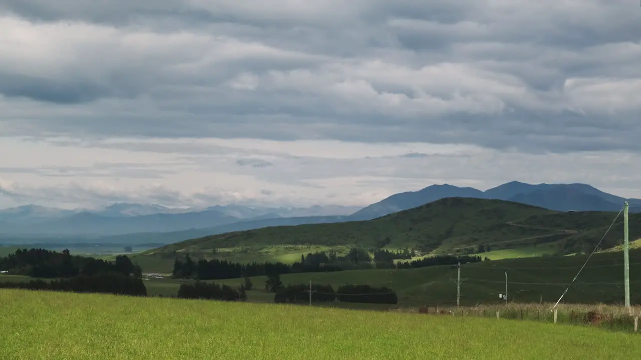 Rolling hills in Green pastures of New Zealand landscape with dramatic clouds