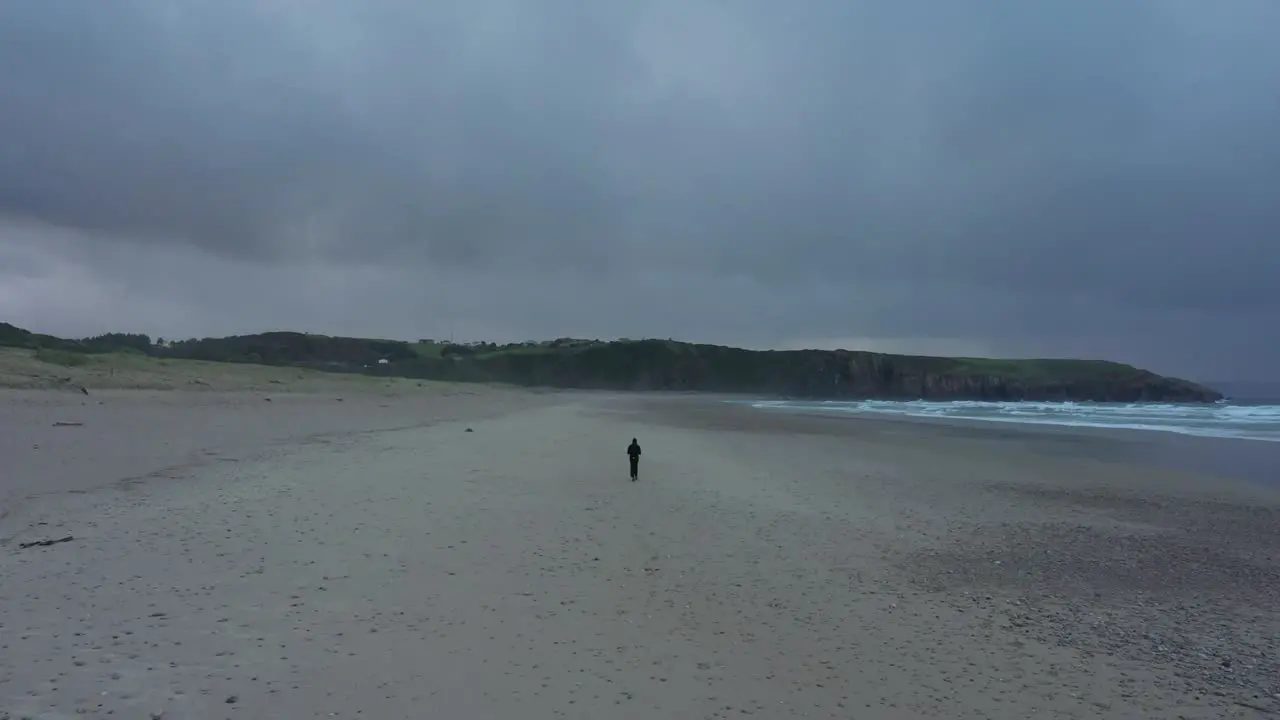 Lone Man Walking On Sandy Beach Of Playa de Xago With Overcast In Asturias Spain