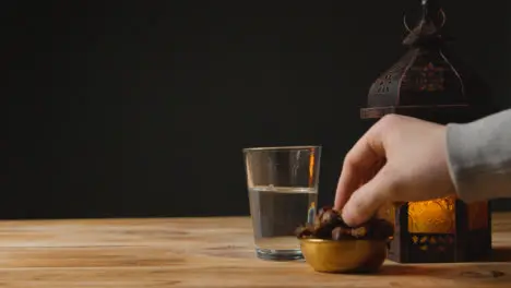 Tracking Shot of Hand Taking a Glass of Water and Date On a Table for Ramadan